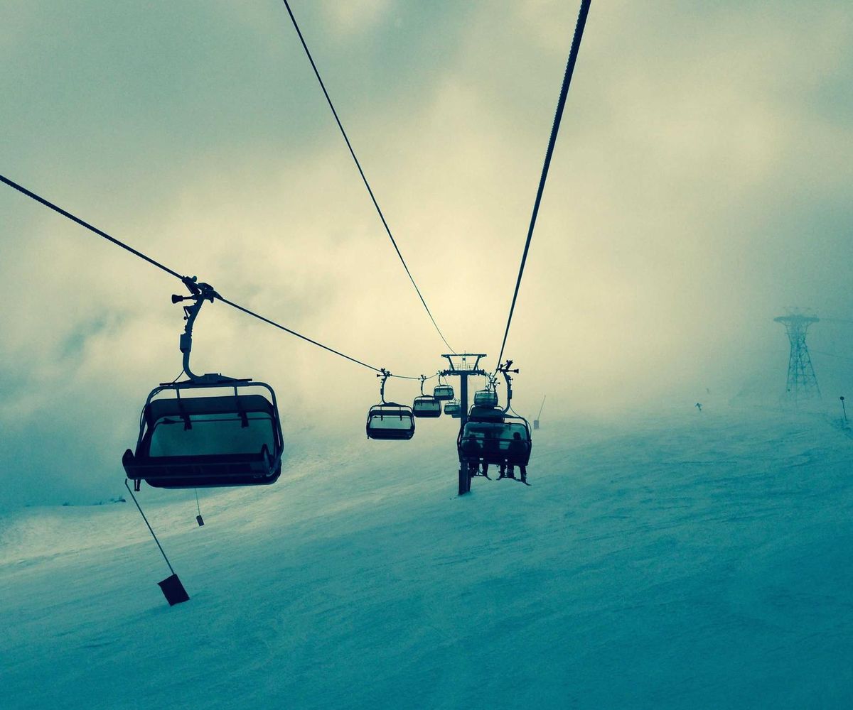 Cable cars gliding up a misty mountainside